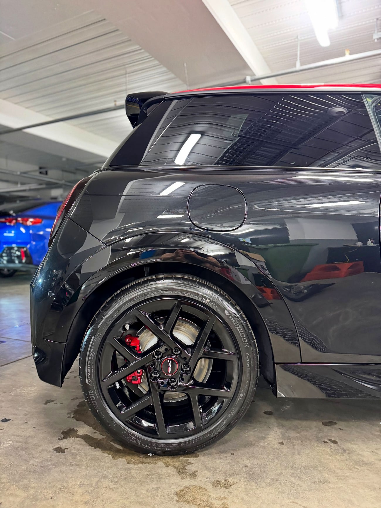 Glossy black paintwork and a clean alloy wheel after detailing